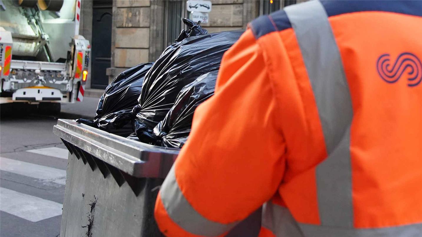 Collaborateur SUEZ collectant des déchets