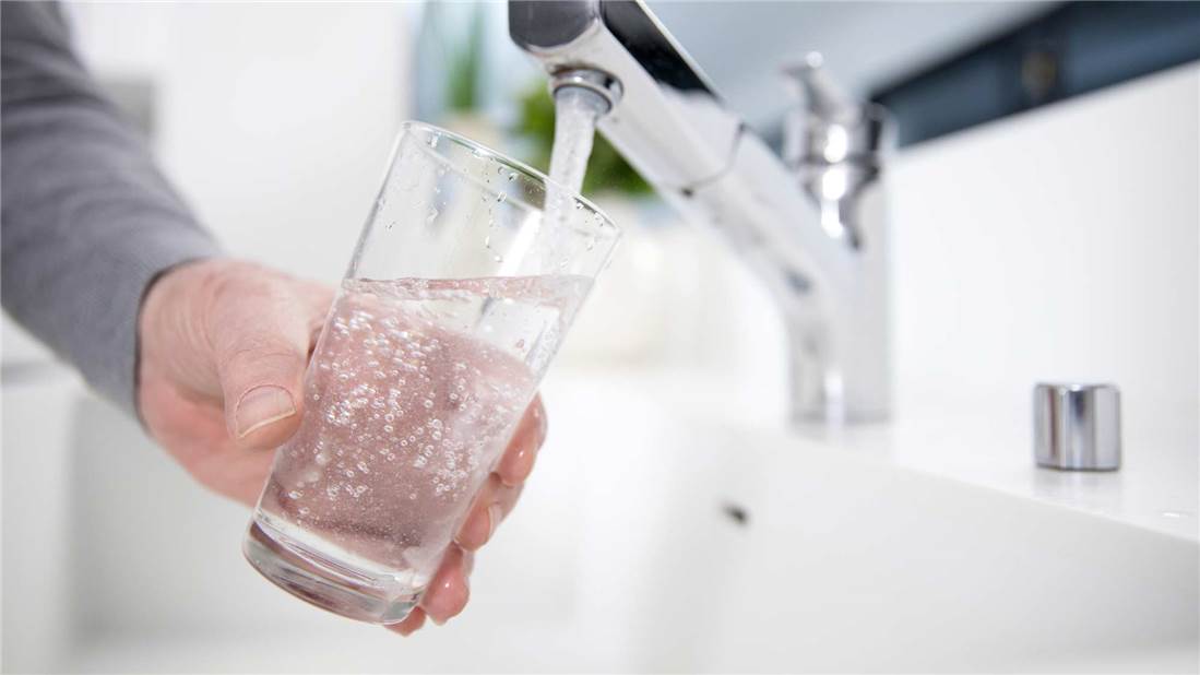 Verre-eau-robinet Person filling a glass of water from a kitchen faucet