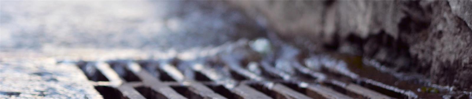 Plaque-egout Rain water falling into sewerage drainage system