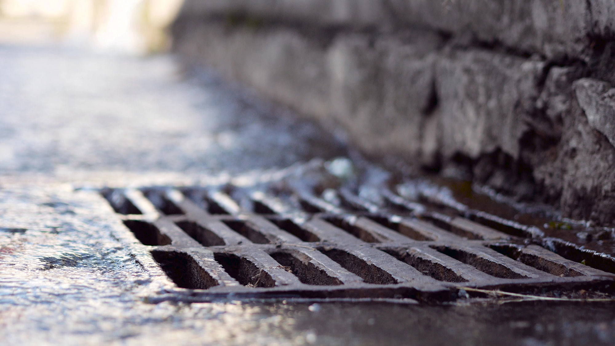 Plaque-egout Rain water falling into sewerage drainage system