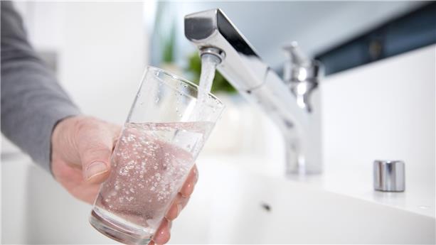Personne remplissant un verre d'eau