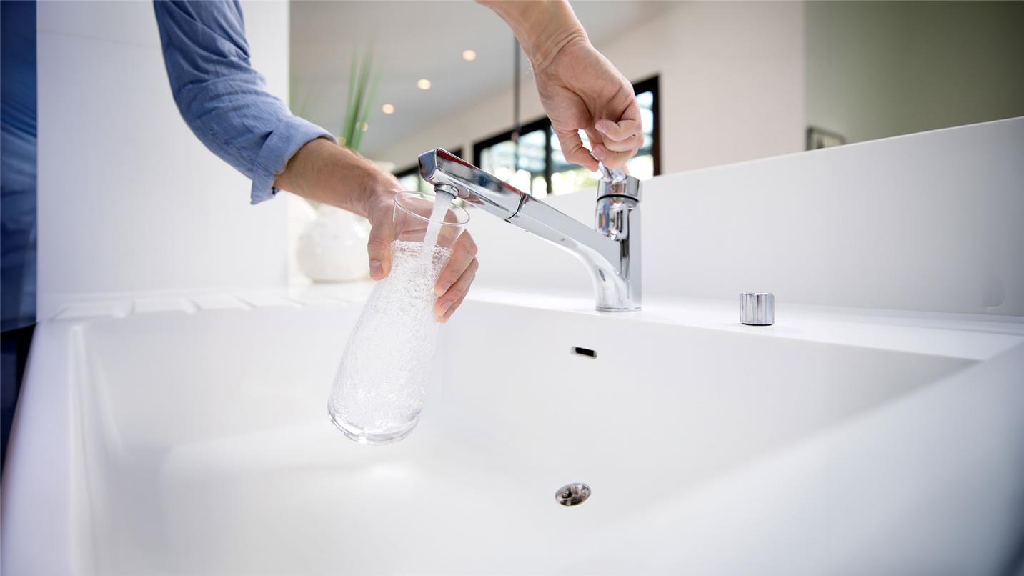 Person-filling-carafe-water Person filling a carafe of water