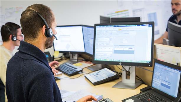 Collaborateurs SUEZ au bureau devant écrans